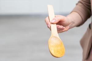 Wooden spoon in hand isolate photo