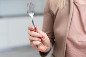 Fork in a hand on a white background isolation photo