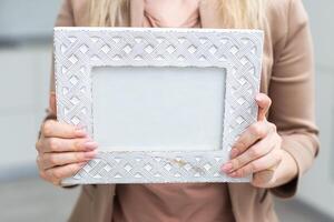 White photo frame in hand on white background. Isolation