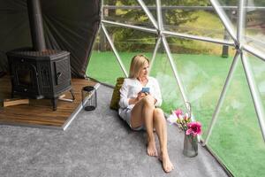 Shot of a beautiful woman using a smartphone while relaxing at home photo