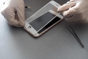 a person places a protective glass or film on a smartphone. copy space. photo