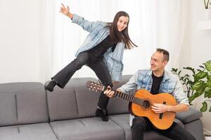 Artistic talented girl showing her latin music teacher the new song she learned to play on the acoustic guitar at home photo