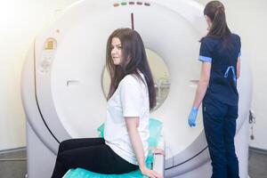 Radiologist with a female patient in the room of computed tomography photo