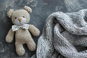 AI generated Cozy knitted teddy bear with a gray bow, perfect for baby shower invites, newborn gifts, nursery decor, and warm, handcrafted product themes with space for text. Generative AI. photo