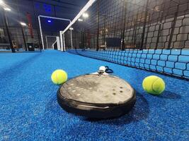 Paddle tennis racket, ball and net on the court photo