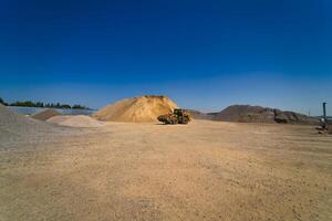 Quarry aggregate with heavy duty machinery. Construction industry. Horizontal photo