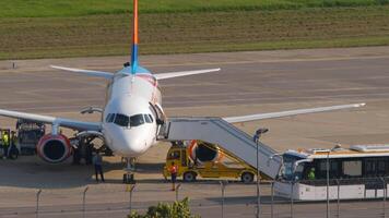 sotsji, Rusland - augustus 02, 2022. sukhoi superjet 100-95 van azimut luchtvaartmaatschappijen ra-89136. passagiers instappen Bij Sotsji luchthaven. schort bus levering van de terminal naar de vliegtuig video