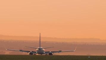 KAZAN, RUSSIA - AUGUST 05, 2022. Boeing 737 of Pobeda Airlines braking after landing. Airplane taxiing at sunset or dawn. Spoilers up. Tourism and travel concept video