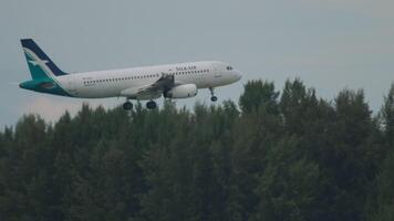 PHUKET, THAILAND - NOVEMBER 27, 2017. Airbus A320-233, 9V-SLS of SilkAir approaching for landing, descending to Phuket airport, side view. Airliner flies over the beach video