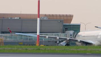 Kazan, Rusland - augustus 05, 2022. passagiers zijn Aan telescopisch loopplank van de vliegtuig noorderwind. mensen wandelen langs de doorgang van de luchthaven naar de Uitgang naar de vlak met Tassen en koffers video