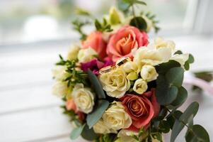 beautiful tender wedding bouquet of cream and pink roses and eustoma flowers in blurred background. Wedding details concept. photo