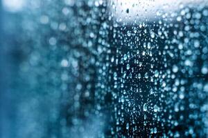 Raindrops on window glass. Selective focus. Rainy city background photo