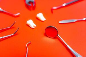 Composition of different dentist equipment. Doctors tools on orange background. photo