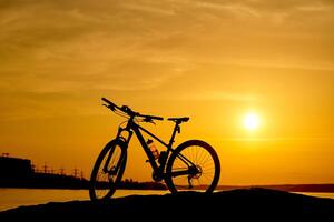 silueta de un bicicleta a puesta de sol. activo estilo de vida concepto foto