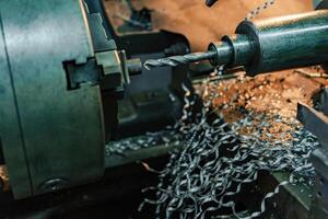 lathe sharpens the part and removes metal shavings at the factory. Close-up photo