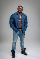 elegante afro modelo en azul camisa posando para cámara. contento atlético hermoso hombre con desnudo torso. foto