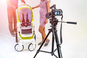 backstage photography. Studio photoshoot. Baby carriage and parents in studio. White background. Crop photo