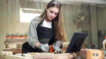 travailleur femme Charpentier en utilisant outils en toute confiance dans permanent tablier travail dans une artisanat atelier. video
