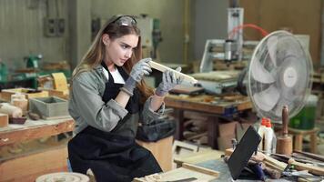 trabalha duro mulher carpinteiro usando Ferramentas com confiança dentro em pé avental trabalhando dentro uma construir oficina. video