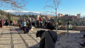 granada, Spanien - februari 2024- människor i mirador de san Nicolas med alhambra i de bakgrund video