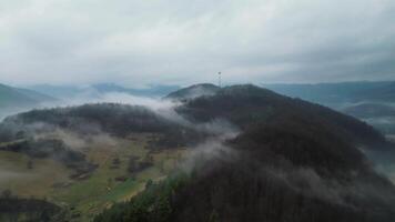 Aerial orbiting view of foggy and cloudy hills and radio tower in Slovakia video