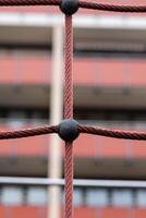 a climbing net from a playground with houses in the background photo