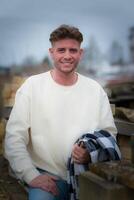 an attractive young man with a white sweater photo