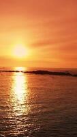 verticale vidéo de magnifique Orange mer plage le coucher du soleil video