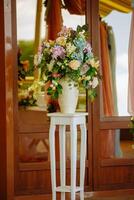 Beautiful tender bouquet on elegant white stand table photo