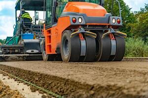 Asphalt road roller. Laying a new asphalt on the road. Road paving photo