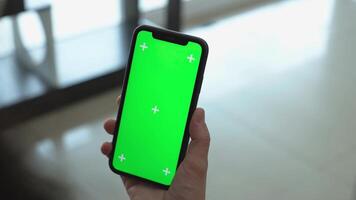 utilizzando smartphone verde schermo nel casa, mano Tenere Telefono verticale video