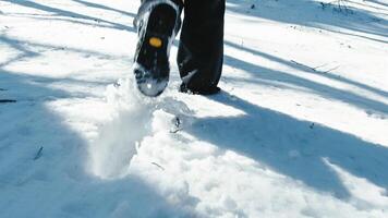 Person slowly walking in the snow with boots leaving traces photo