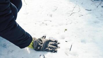 Hand with gloves leaving traces on the snow photo