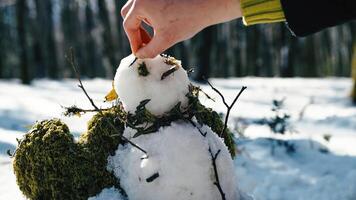 mano completando creación de un monigote de nieve foto