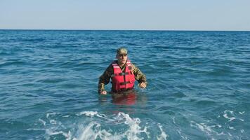 Soldier with life jacket comes out of the sea photo