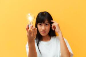 woman holding a glowing light bulb creative business ideas Inspired idea with light bulbs on yellow background. Ideas for success. hand holding incandescent lamp photo