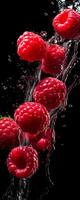 AI generated This tall photo captures the graceful freefall of glistening raspberries and water, their succulent forms suspended in midair, on a black background