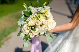Bride holding flower bouquet. Bride in white dress holding a beautiful wedding bouquet in her hands photo