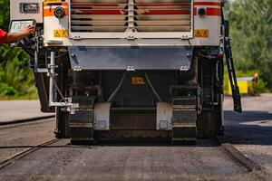 Roadworks on laying of a new of asphalt, selective focus on wheel, heavy technic, closeup photo