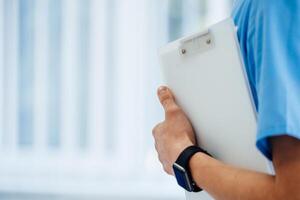 Close up of male doctor holding the folder. Closeup with blurred background. photo