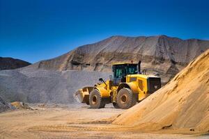 Maintenance of yellow excavator on a construction site against blue sky. repearing wheel loader at sandpit during earthmoving works photo