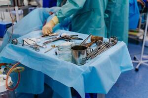 Nurse hand taking surgical instrument. Steel medical instruments ready to be used. Surgery and emergency concept photo