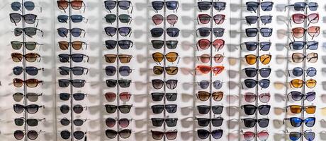 Gafas de sol en un almacenar. escaparate con gafas en moderno oftálmico almacenar. foto