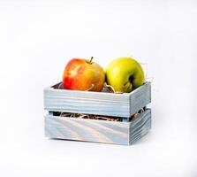 sweet apples in wooden crate, isolated on white photo