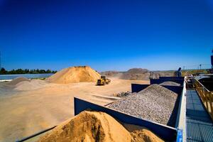 Sand quarry, excavating equipment, bulldozer with heap of sand and gravel in background. Selective focus. photo