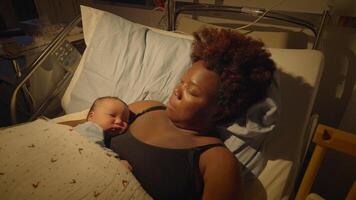 Young African Mother Lying in Hospital Bed Holding Newborn Baby After Birth video