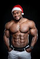 Sexy athletic bodybuilder in christmas hat posing for camera. Muscular handsome man with naked torso. photo