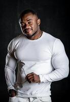 atractivo muscular hombre en blanco camisa posando para cámara. sexy hermoso persona en oscuro antecedentes. foto