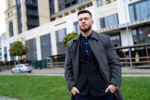 hombre en Saco es acecho bellezas de ciudad. joven Moda turista caminando alrededor moderno ciudad. hermoso hombre de negocios quedarse a urbano calle. foto