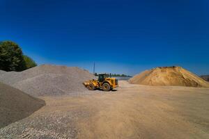 Quarry aggregate with heavy duty machinery. Construction industry. Horizontal photo